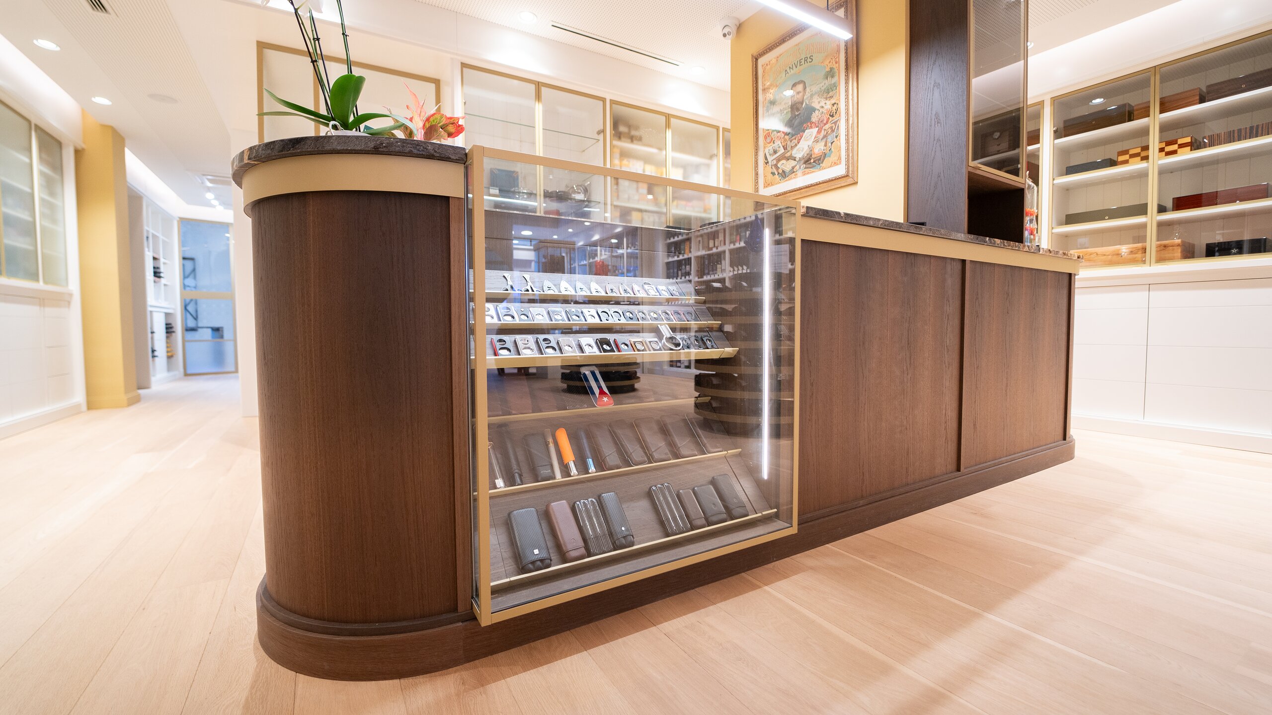 Comptoir de vente en bois foncé intégrant une vitrine en verre éclairée pour les cigares et accessoires
