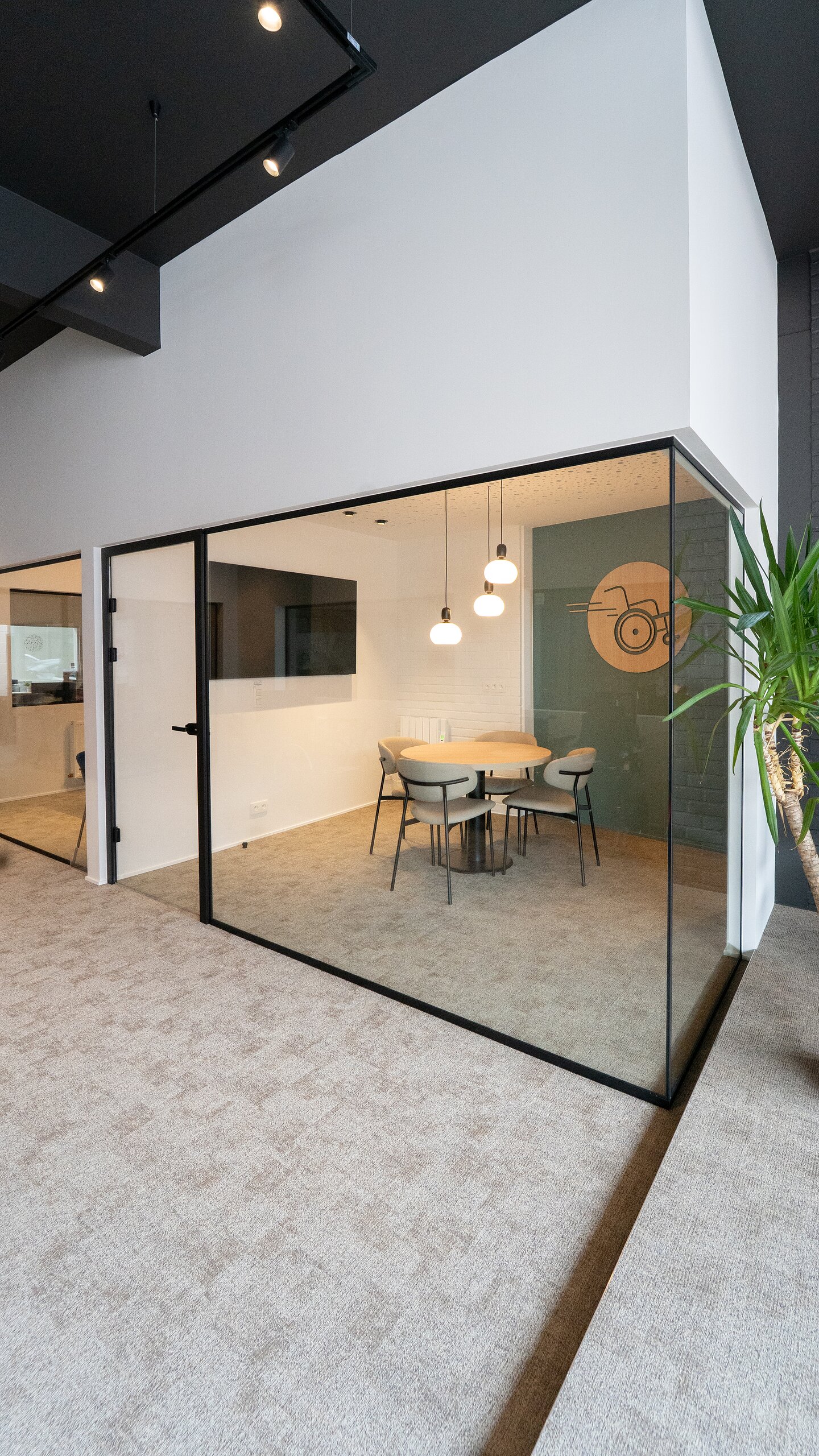 Salle de réunion d'angle entièrement vitrée, verre clair tenu par des profilés noirs du sol au plafond